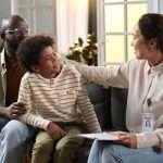 A father and son sit together during a therapy session.