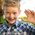 A boy with ADHD smiles as he shows off his fidget spinner.
